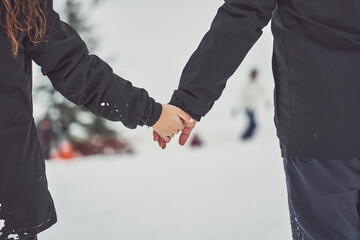 Young Couple in Love Walking Hand in Hand in Snowy Swiss Alps