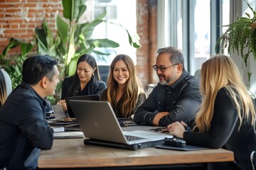 Diverse Group of Professionals Meeting Around a Table with Laptops