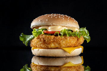 Burger with chicken cutlet, salad and mayonnaise. Top bun is slightly sideways. Side view