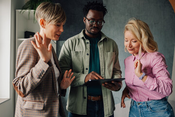 Marketing team analyzing data on tablet and discussing strategy