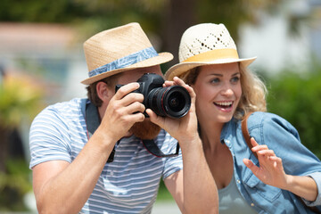 joyful couple of tourists male and female photographing landmarks