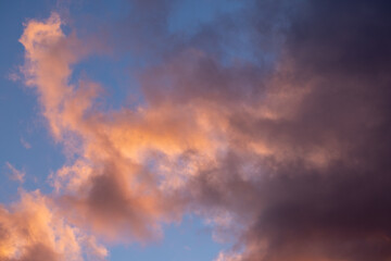 Sunset painting the clouds with warm hues in blue sky