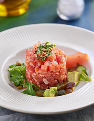 Delicious tuna tatar or tar-tar on white plate. Red fish fillet. Delicious food. Culinary concept.