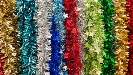 Multicolored tinsel as a background, closeup of photo. Colorful tinsel decoration for Christmas and New Year holidays background.