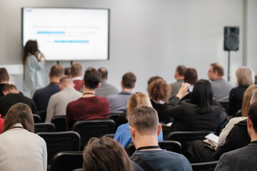 Fototapeta premium Group of professionals engaged in presentation at business conference. Speaker giving talk to attentive audience. Participants learning and networking.