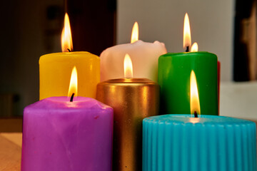 Colorful candles burning in a cozy indoor setting