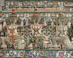 Fototapeta premium Yaksha and monkey supporting figures decorating the prang of the Arun Temple in Bangkok, Thailand