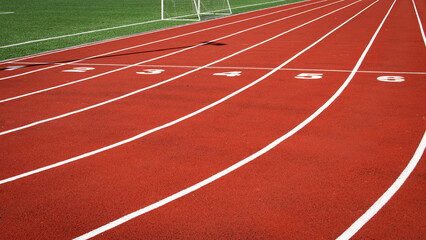 Running track of an open sports stadium made of a special surface, marked into 6 (six) lanes with...