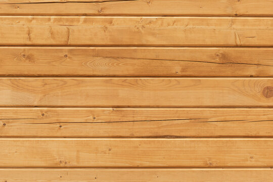 Background of freshly sawn cracked wooden boards arranged horizontally.