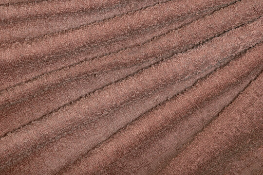 Background made from a crumpled cotton towel folded into folds. Trending color of the year 2025 Mocha Mousse.