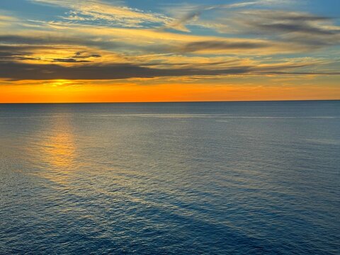 Blue calm ocean and sunrise sky clouds. 