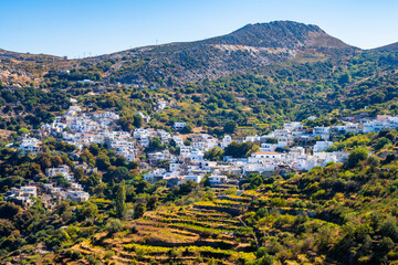 White houses and buildings of Koronos mountains village located on high green hills, Naxos island,...