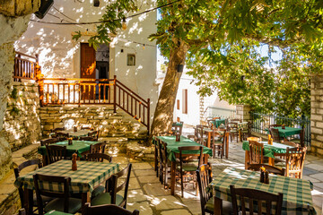 Tables with chairs in Greek taverna restaurant in Koronos mountain village, Naxos island, Cyclades, Greece