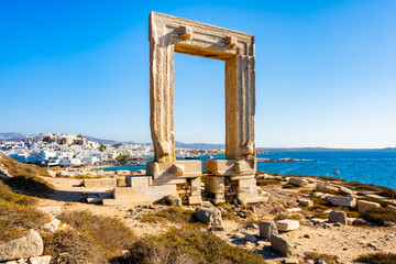 Portara monument also known as Temple of Apollo overlooking port and town on sea coast, Naxos...