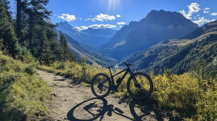 Fototapeta premium Mountain bike resting on a trail with dramatic mountain scenery bright sunlight casting sharp shadows adventure and outdoor spirit