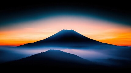   A mountain shrouded in fog at sunset, with an orange-blue sky in the foreground and an orange-blue sky in the background