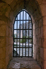 An old window with an iron grill and stone frame