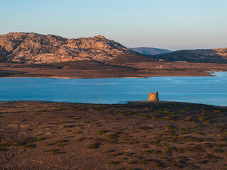 A drone shot of La Pelosa beach during golden hour. Pastel colors and an idyllic Sardinian...