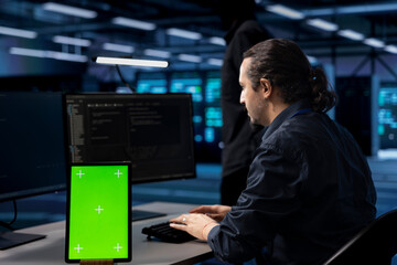 Engineer in server hub ensuring data remains shielded from potential threats using isolated screen...