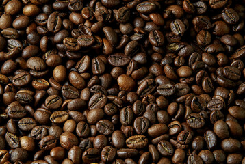 Fototapeta premium Coffee beans close-up roasted brown texture background aromatic caffeine beverage ingredient macro photography high resolution food and drink concept