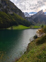 A clear lake in a swiss alp mountain during a cloudy evening in september