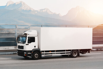 Efficient White Cargo Truck Driving In Picturesque Mountain Route for Seamless Logistics