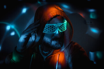 Man wearing futuristic neon light glasses and hoodie in cyberpunk setting