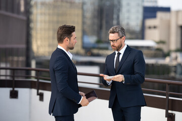 A man and a man exchanging a business card. one businessman gives another businessman his business...