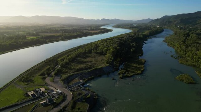 Panoramic view of the Rhone river bed in southern France with a passing passenger ship during sunrise on an autumn morning.