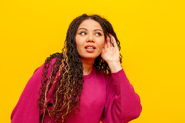 curious plump african american woman with pigtails eavesdropping on secret on yellow isolated...
