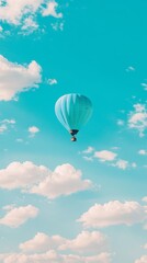 Obraz premium A single blue hot air balloon floats against a clear blue sky with white fluffy clouds.