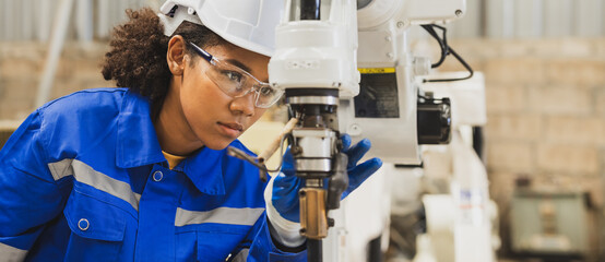 African american engineer woman fixing and testing an Artificial Intelligent welding robotic...
