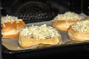 Savory cheese-filled buns baking in oven delight the senses with warmth and aroma