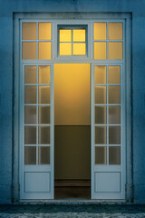 Wooden doors opened at night with an illuminated background. 