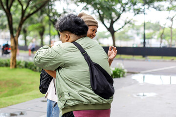 Cheerful Best Friends Embracing Each Other On Park.

