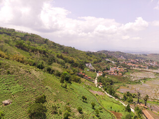 Majestic Ridge in the Cicalengka highlands, Indonesia. Gentle slopes with panoramic rice fields and villages along the valley. Countryside View. Drone Aerial. Landscape Photography