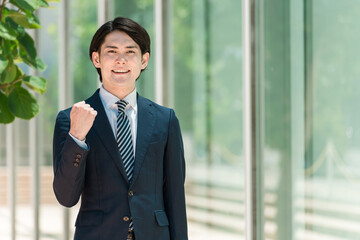 Fototapeta premium 会社・オフィスに出勤・出社・通勤する若い男性アジア人ビジネスマン 