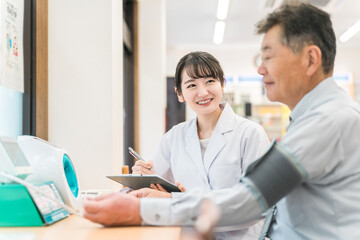 病院・クリニックで人間ドック・健康診断する男性と医師（血圧）
