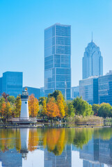 Obraz premium Beautiful landscape of golden autumn season at Yinzhou Park, with background of modern buildings of Southern Business District (Ningbo CBD) in Ningbo, Ningbo, Zhejiang, China