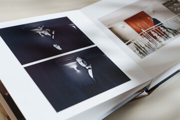 page of an open photo book with wedding photos on a white table
