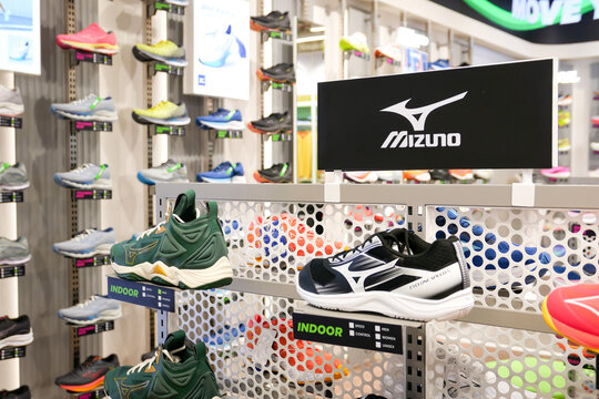 MIZUNO Running shoes are against the wall on display at a running shoe specialty store. Mizuno is a Japanese sports shoes equipment and sportswear.