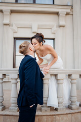 Happy and in love bride and groom on the balcony at the railing at the entrance 