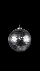 Shiny silver disco ball hanging in the air on black background