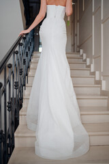 Fototapeta premium view from the back. a Beautiful and happy bride on a large beautiful staircase.