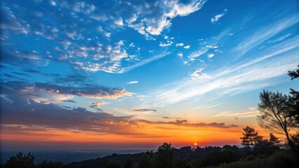 A breathtaking sunset panorama, vibrant colors paint the sky with fiery hues and fluffy clouds