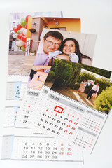 tear-off calendars with family photos on a white table. 