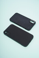 Black case for smartphone isolated on blue background. High resolution photo.