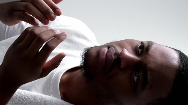 Vertical video. Skin problem. Acne treatment. Allergy irritation. Annoyed dissatisfied disturbed man touching dry face looking in mirror.