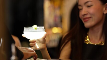 Smiling beautiful woman zipping Margarita cocktail savoring tasty drink making special time by bartender at luxurious bar creating moment meeting with friends or a couple vibrant nightclub. Vinosity.