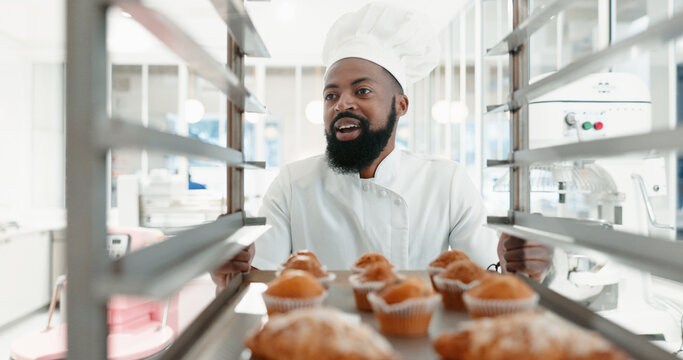Muffin, bakery and cooking with black man in kitchen for coffee shop, food industry and breakfast. Shelf, chef and nutritionist with baker and dessert in restaurant for baking, cafe and order